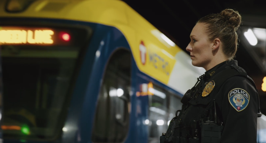 Metro Transit Police Officer standing by a METRO train
